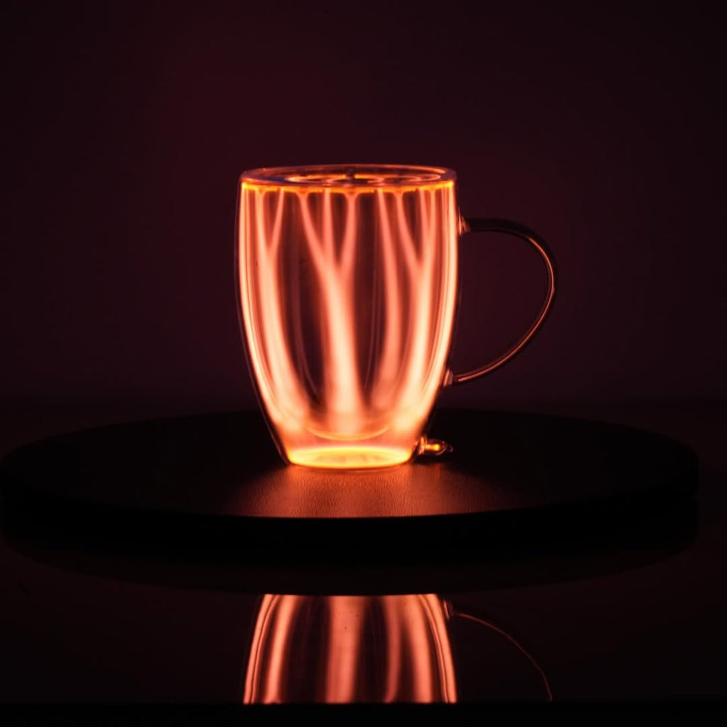 Plasma Mug by Astro Labs glowing with red plasma filaments inside a clear double-walled glass mug on a powered base.